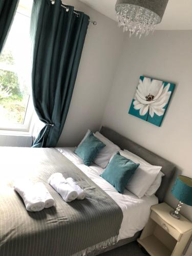 1 dormitorio con 1 cama con almohadas verdes y blancas en Number Fifty Six en Hawick