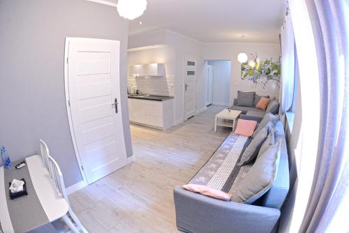 a living room with a couch and a kitchen at Apartamenty Zamkowa in Jelenia Góra