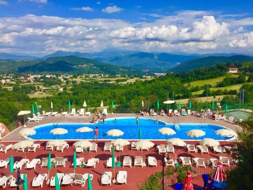 vistas a una piscina con sillas y sombrillas en Residenza Vallefiorita en Rocchetta a Volturno