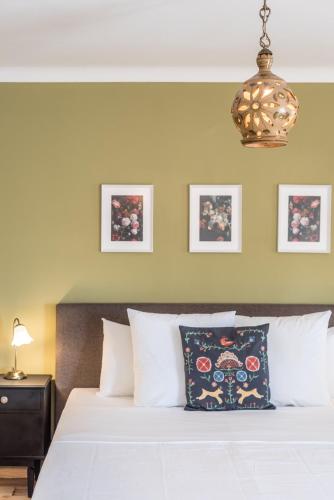 a bed with white pillows and a chandelier at Quinta da Paz B&B in Portimão