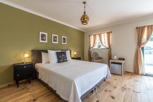 a bedroom with a large white bed and green walls at Quinta da Paz B&B in Portimão