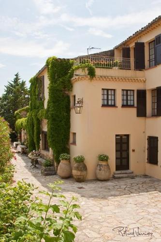 a building with plants growing on the side of it at Hotel-Restaurant Le Moulin De La Camandoule in Fayence