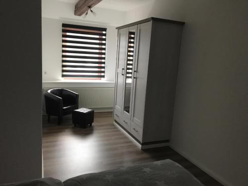 a living room with a chair and a window at Hademarscher Hof in Hanerau-Hademarschen