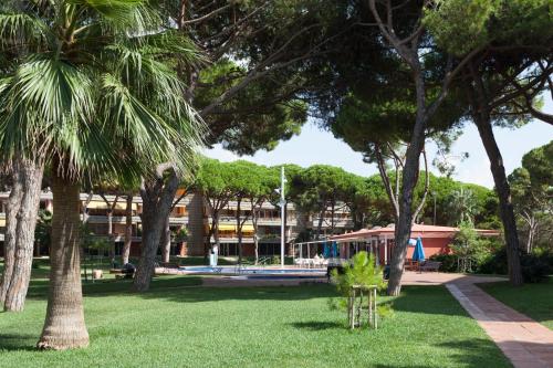 a park with palm trees and a building at Gava Mar- Castelldefels Beachfront Apartment- Direct access to the beach in Gavà