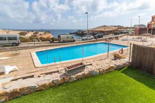 a swimming pool with the ocean in the background at Urbanización Cala fría (Faro Cabo de Palos) in Cabo de Palos