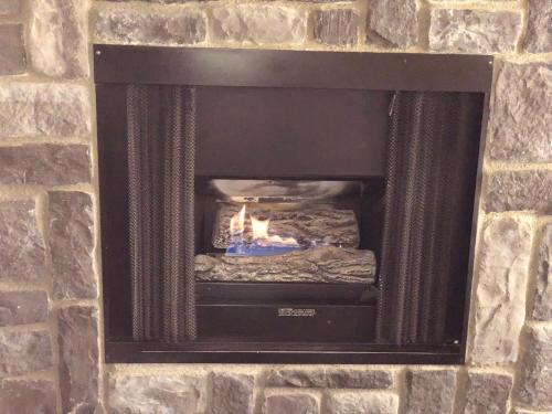 a brick fireplace with a fire in it at Fireside Lodge in Big Bear Lake