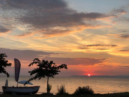a boat on the beach with a sunset in the background at Sunsets in Thassos 2 in Skala Sotiros