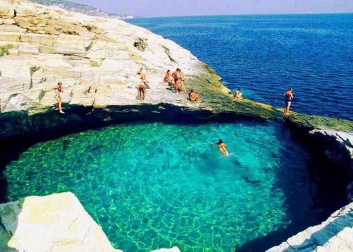 a group of people swimming in a cave in the water at Sunsets in Thassos 2 in Skala Sotiros