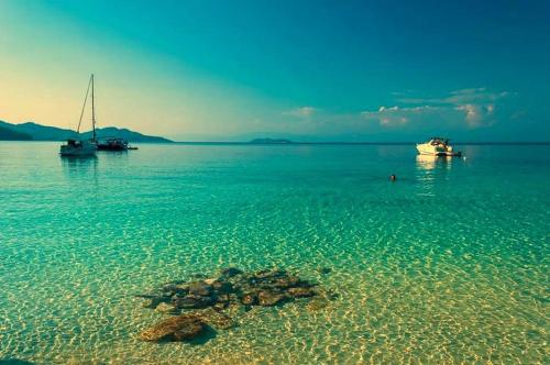a beach with two boats in the water at Sunsets in Thassos 2 in Skala Sotiros