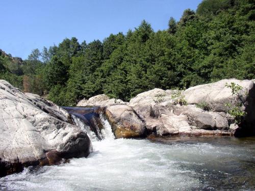 a river with rocks and waterfalls at Gîte le Petit Riou in Sainte-Marguerite-Lafigère