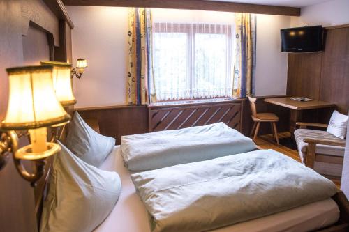 a hotel room with two beds and a lamp at Gasthof Pension Traube in Karres