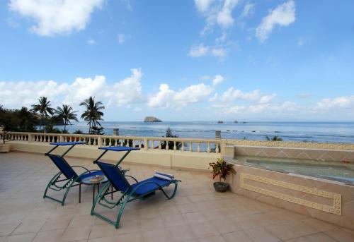 two chairs and a table on a patio overlooking the ocean at Bali Seascape Beach Club in Candidasa