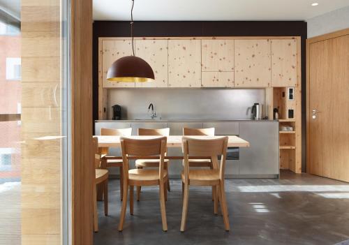 a kitchen with a table and chairs in a kitchen at Alpine Lodge Chesa Plattner in Pontresina