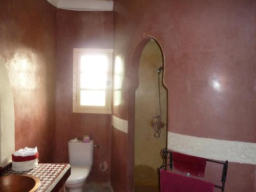 a bathroom with a toilet and a sink and a window at Riad-villa Agadir-Taroudant in Sidi Boumoussa