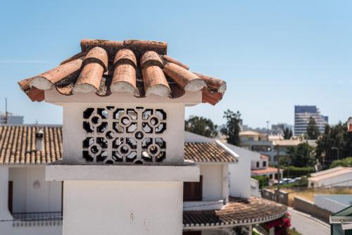 a building with a tile roof on top of a building at Quinta da Paz B&B in Portimão