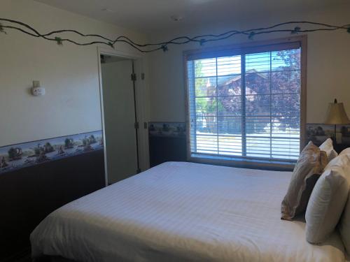 a bedroom with a large white bed with a window at Fireside Lodge in Big Bear Lake