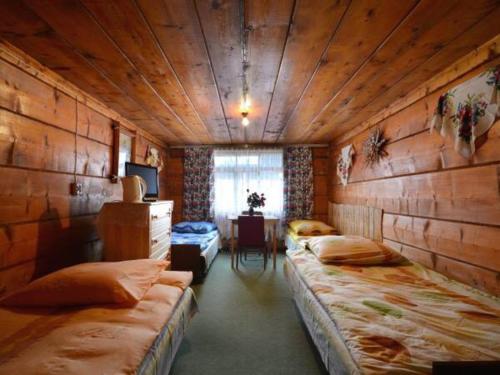 a room with two beds and a table in it at Góralskie Pokoje in Witów