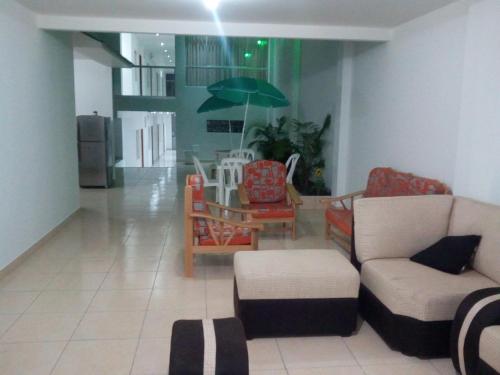 a living room with a couch and a table with an umbrella at Antares Paracas in Paracas
