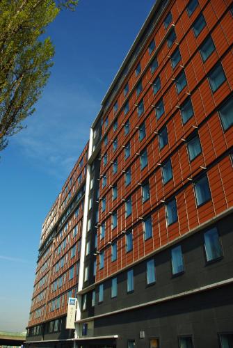 a large red brick building with a blue at Greet Hotel Paris porte de la Chapelle - Aréna in Paris
