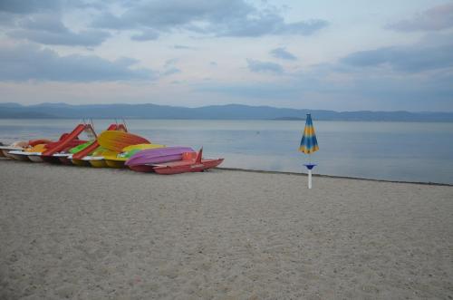 a row of kayaks and an umbrella on a beach at Il Torrione in Castiglione del Lago