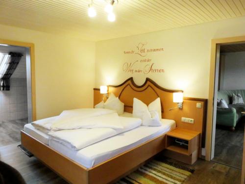 ein Schlafzimmer mit einem Bett mit einem Schild an der Wand in der Unterkunft Pension Weiß in Hohenwarth