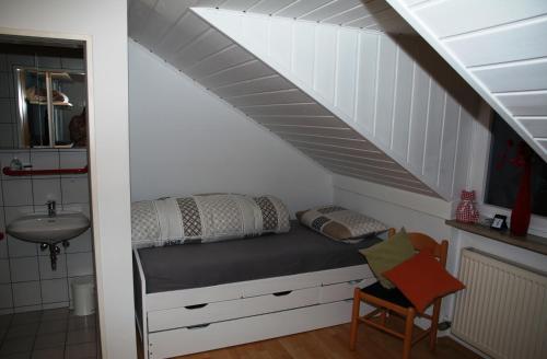a bedroom with a bed under a staircase with a sink at Ferienhaus LIVI in Zandt