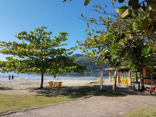 a beach with chairs and trees on the beach at Pousada Char in Ubatuba