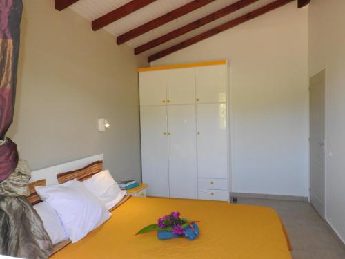 a bedroom with a yellow bed with flowers on it at Kreyol Eden Cottage in Le Gosier