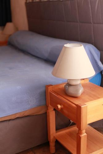 una lámpara en una mesa junto a una cama en Domaine de la Saule, en Jalogny