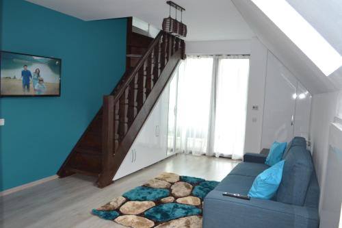 een blauwe woonkamer met een blauwe bank en een trap bij Apartament Golden Rose in Buşteni