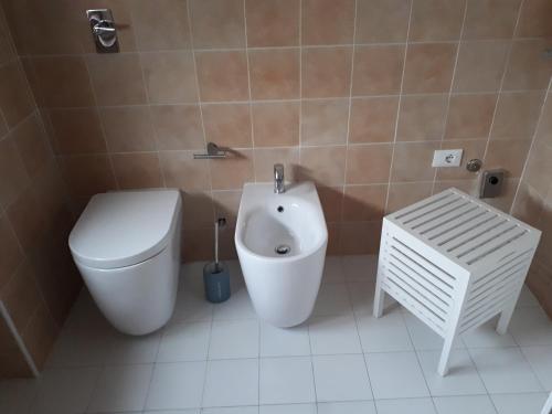 a bathroom with a toilet, sink, and bathtub at La casa di Mango e Pistacchio in Segrate