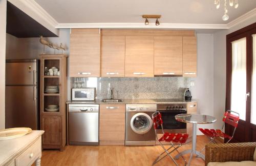 a kitchen with stainless steel appliances and wooden cabinets at Apartamentos Alcoba de Baco in Barbastro
