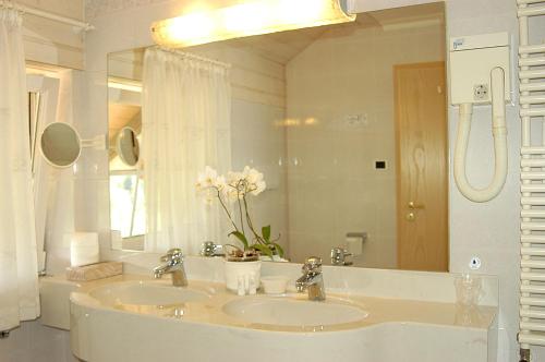 a bathroom with two sinks and a large mirror at Hotel Dolomitenblick in Collalbo