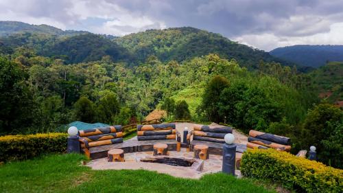 a bench sitting on top of a hill with mountains in the background at Rushaga Gorilla Lodge in Bugambira