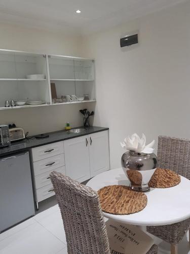 a kitchen with a white table and chairs and a table and chairsktop at Meraki Country Manor in Lanseria