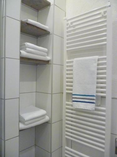 a bathroom with white towels and a towel rack at Moderne Wohnung in barockem Altstadthaus nahe Altstadt und Radweg in Blieskastel