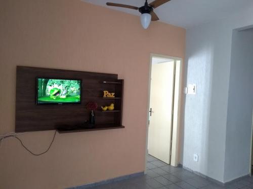 a living room with a television on a wall at Casa Praia do Forte in Cabo Frio