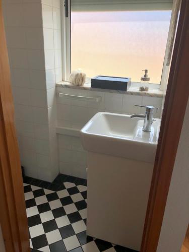 a bathroom with a sink and a window at Sunset view apartment in Figueira da Foz