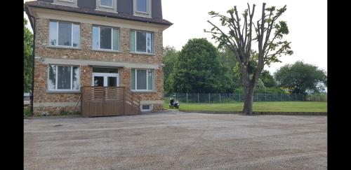 a large brick house with a tree in front of it at Country House Reem in Pommeuse