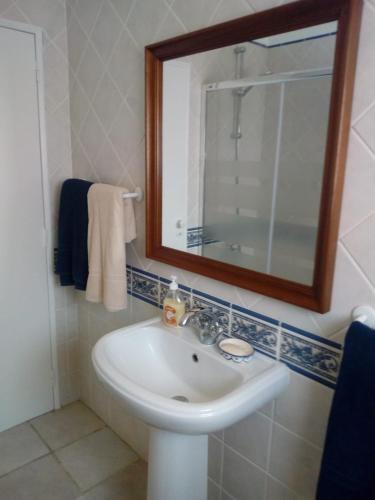 a bathroom with a sink and a mirror and towels at Family Villa Pool & Beach in Caparica