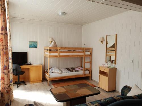 a bedroom with a bunk bed and a desk with a computer at Pension Am Mellensee in Saalow