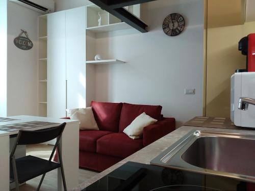 uma sala de estar com um sofá vermelho numa cozinha em Kibilù - Viale Bligny - Porta Romana - Università Bocconi em Milão