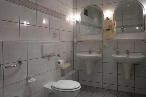 a bathroom with two sinks and a toilet and a mirror at VillaMirage in Tarnowskie Góry