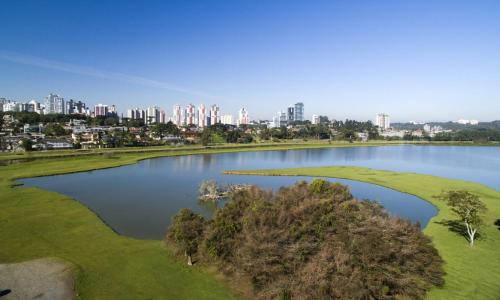 a view of a lake with a city in the background at Oberon in Curitiba