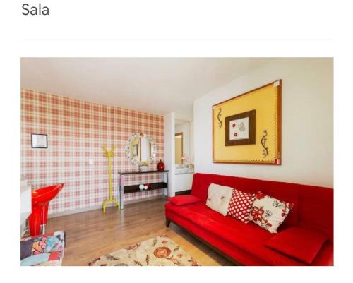 un soggiorno con divano rosso in una camera di Anitta 2 a San Paolo