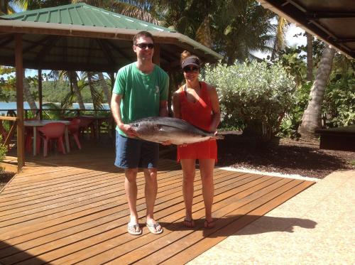 a man and woman holding a fish on a deck at La Sagesse Hotel, Restaurant and Beach Bar in Content