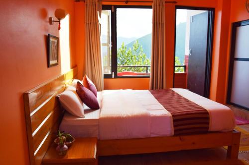 1 dormitorio con 1 cama con paredes de color naranja y ventana en Siddhartha Garden Ayurveda en Pokhara