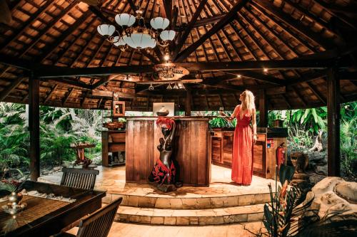 a woman in a red dress standing at a bar at Rohotu Fare in Bora Bora