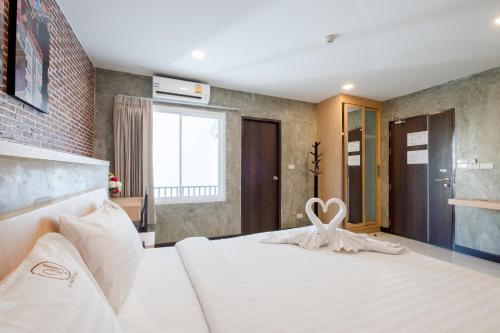 a bedroom with a white bed with a heart decoration on it at U Hatyai Hotel in Hat Yai