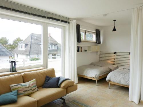 a living room with a couch and a bed and a window at Ferienwohnung *Krabbe 25* in Wittdün